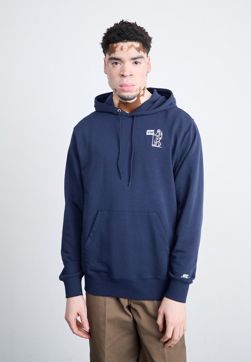 Sudadera de marina en mezcla de algodón con bolsillo delantero, capucha con cordón y logo gráfico blanco en el pecho. Puños y dobladillo acanalados.