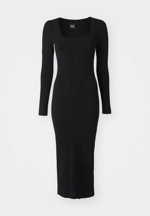 Robe noire à manches longues avec décolleté carré, texture côtelée, silhouette ajustée et rayures verticales pour un détail supplémentaire.