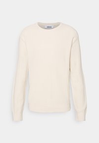 Pull en tricot beige clair avec un col rond, des manches longues et des poignets côtelés. Tissu doux et texturé avec un minimum de décorations.
