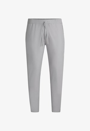 Heledad hallhallid, mis on valmistatud siledast kangast, millel on elastne vöökohus jooksutrossiga ja kitsenevad püksijalad ribatud soonikutega.