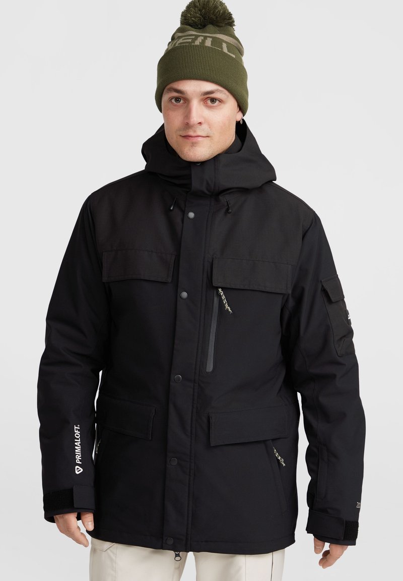Černá zimní bunda s kapucí, která má několik kapes, zipovou náprsní kapsu a branding Primaloft na rukávu.