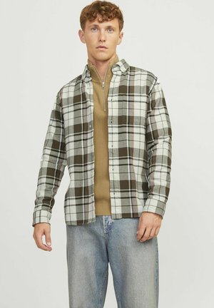 Plaid flannel shirt in gray and brown with white accents, button-down design, and long sleeves. Worn over a beige fitted zip-up sweater.
