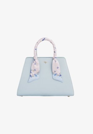 Jasnoniebieska torebka trapezowa z szalikiem w kwiatowy wzór owiniętym wokół rączek oraz małą złotą ozdobą w kształcie pszczoły umieszczoną centralnie blisko górnej części.