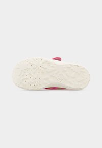 Λευκή σόλα παιδικού παπουτσιού με υφασμένο σχέδιο πιτσιλιών, μικρές τρύπες και την ένδειξη "superfit" ορατή στη βάση.