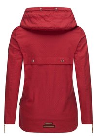 Chaqueta impermeable roja con capucha, que presenta un patrón de puntos, dos bolsillos en el pecho y cremalleras laterales para ventilación. Tejido duradero con detalles.