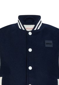 Marineblauwe varsityjack met een witte gestreepte kraag, drukknoopsluiting en een textuurpatch met 'RETOUR' branding op de linkerborst.