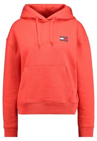 Coral pullover hoodie made of soft fabric, featuring a front pocket, drawstring hood, and a small logo patch on the chest.