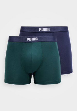 Kaks paari poiste bokserite pükse: üks roheline ja teine tumesinine. Mõlemad on valmistatud pehmest kangast ja neil on elastne vöö, millel on valge "PUMA" logo.