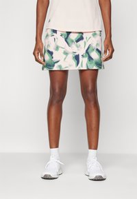 Färgglad, mönstrad sportkjol med nyanser av grönt och marinblått på en ljus bakgrund; lättviktsmaterial med mjuk yta och elastisk midja.