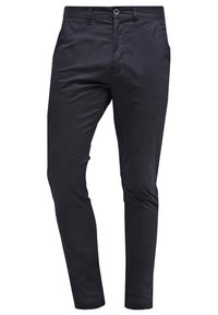 Szczupłe czarne spodnie męskie z zapięciem na guzik i zamek, kieszeniami bocznymi oraz szlufkami na pasek, wyeksponowane na białym tle.