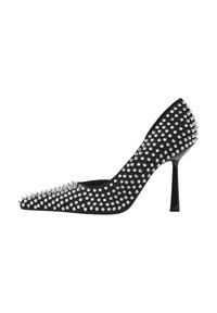 Schwarzer High Heel mit spitzer Zehenpartie, bedeckt mit silbernen Nieten. Glatte Textur mit glanzvollem Absatz. Verfügt über ein Stiletto-Design.