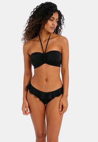 Black bikini set featuring a bandeau top with ruching and adjustable straps, paired with low-rise bottoms adorned with a ruffled trim.