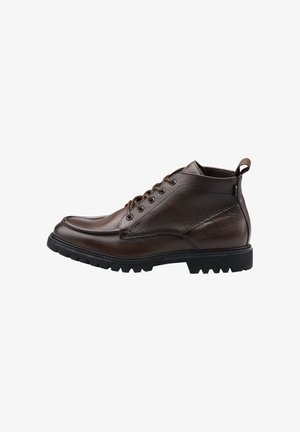 Bruine leren enkelboots met een gestructureerde afwerking, ronde neus, vetersluiting en een stevige zwarte rubberen zool met een diepe profiel.