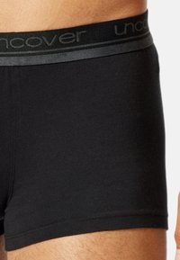 Boxer shorts neri in cotone con elastico logo, caratterizzati da una vestibilità aderente, una texture liscia e senza ulteriori motivi o decorazioni.