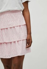 Jupe en tulle rose clair à plusieurs niveaux, en tissu brodé, avec un ourlet festonné, des motifs à œillets et une taille élastique.