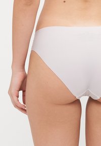 Šviesiai rožinės, sklandžios medžiagos hipster tipo apatiniai drabužiai su žemu kirpimu, pasižymintys bejungiamais kraštais ir minimalistiniu dizainu.