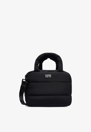 Bolso rectangular acolchado negro con asas redondeadas, una correa de hombro desmontable y una etiqueta frontal de parche que dice "G-STAR ORIGINALS RAW".