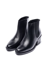 Botines de cuero negro con acabado liso, punta puntiaguda, paneles laterales elásticos y tacón ancho. Cuenta con cremallera lateral para cierre.