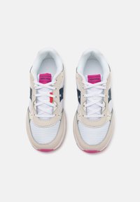 Baskets de sport beiges et blanches avec une tige en mesh, accents roses et logo bleu marine. Elles disposent de lacets ronds et d'une semelle texturée.