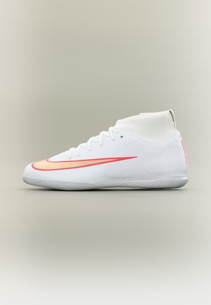 Hvid atletiksko med rød Nike-swoosh, høj ankelkrave, flad sål og snørebånd, vist på neutral baggrund.