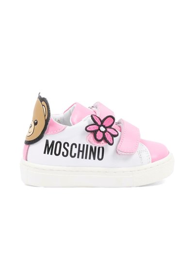 Baskets pour enfants blanches et roses avec texte "Moschino" noir, patch fleur rose sur la bride, et visage d'ours en peluche sur le talon.