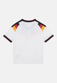 Camiseta blanca de manga corta con tejido texturizado y detalles de rayas negras, rojas y amarillas en los hombros y el cuello.