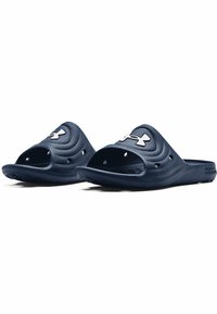 Chanclas de color azul marino con parte superior texturizada, punta abierta y orificios de drenaje. Presenta un logotipo blanco en contraste en la parte delantera.