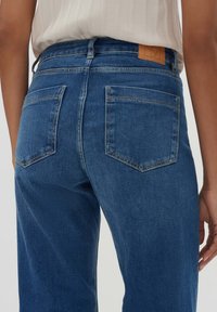 Denim jeans in middengrijs, met een hoge taille, rechte pijpen, twee achterzakken en een leren label op de tailleband.