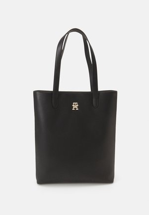 Borsa tote in pelle nera con due lunghe maniglie, texture liscia, design minimalista e accento del logo dorato sulla parte frontale.