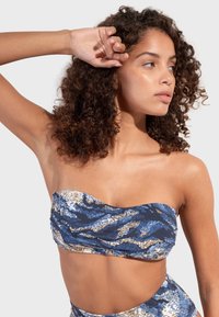 Bikini top bez ramienok v modrej, zlatej a krémovej vlnitej vzore; textúrovaná tkanina s zbernou detailom; bezšvová konštrukcia pre pohodlie.