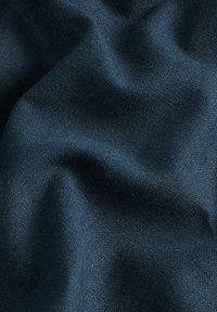 Tela texturizada de color azul oscuro con un aspecto ligeramente arrugado. El material muestra un tejido uniforme, destacando su suavidad y profundidad.