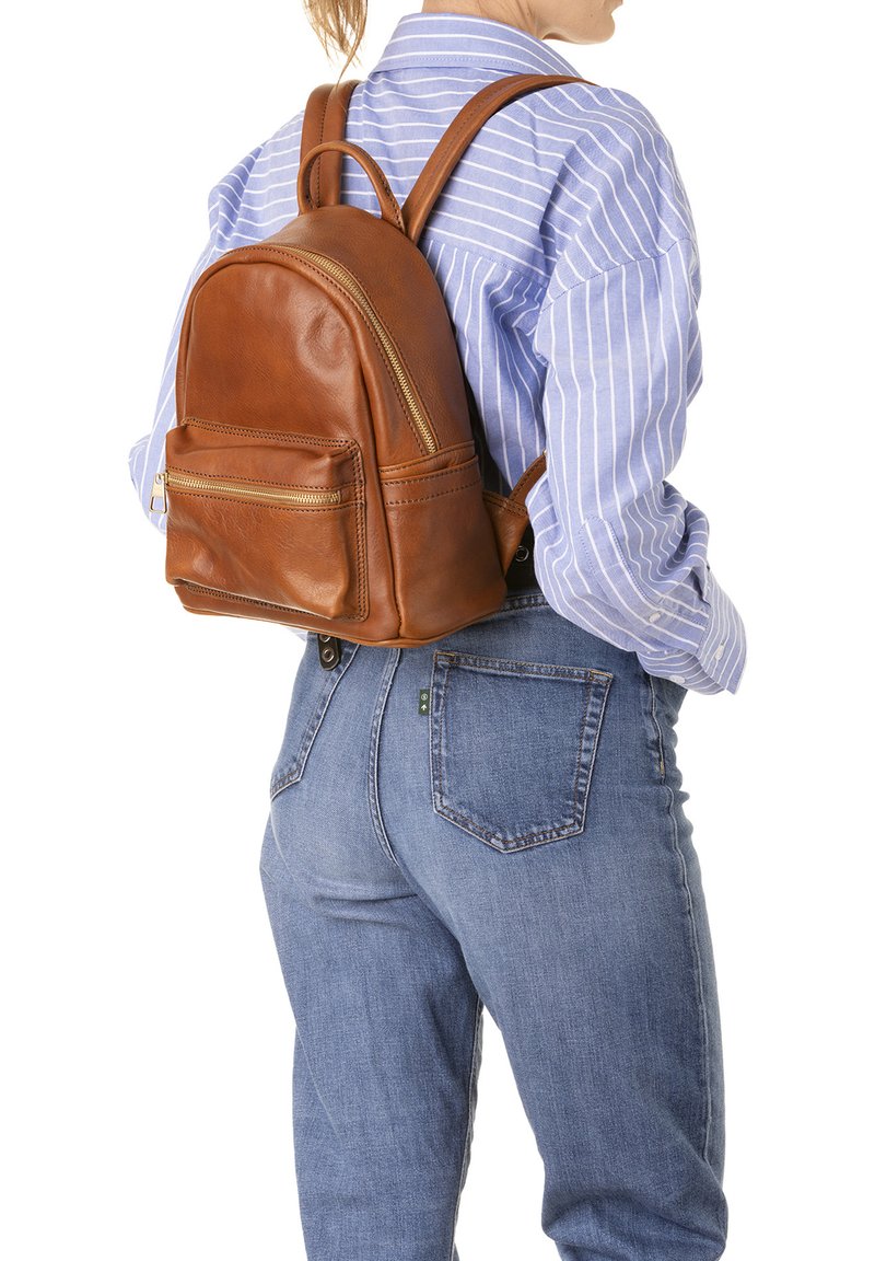 Zaino in pelle marrone con forma arrotondata, tasche con cerniera e spallacci regolabili. Presenta una texture liscia e minimo hardware.