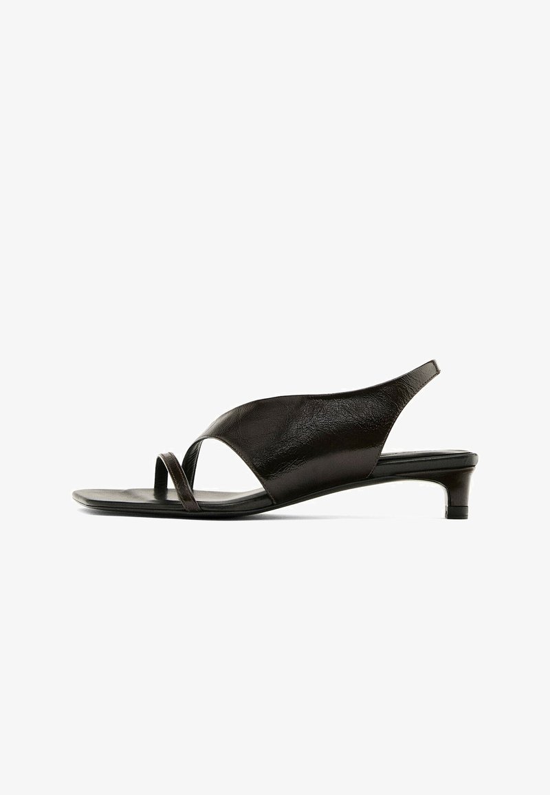Black leather sandal with a low heel, featuring a wide front strap and thin crossover toe bands for secure fit and comfort.