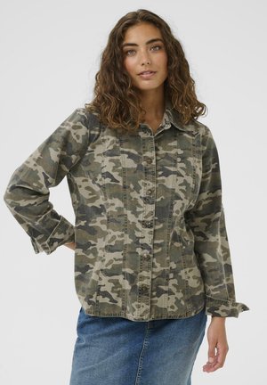 Veste en jean à motif camouflage dans des tons verts, avec un devant à boutons, un col classique et des manches longues aux poignets retroussés.