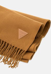 Brązowy dziergany szalik z frędzlami oraz trójkątną skórzaną metką z nazwą marki. Gładka faktura i prostokątny kształt.