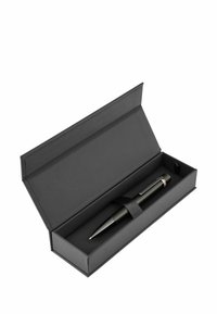 Un stylo noir enfermé dans une boîte noire rectangulaire, maintenu avec une sangle en tissu noir. Le stylo présente une finition lisse et des accents en argent.
