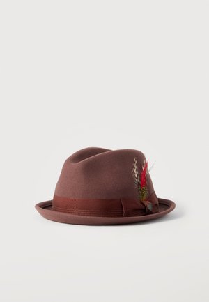 Brun filt fedora hat med et satinbånd og dekorative røde og brune fjer på siden mod en ensfarvet baggrund.