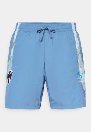 Blå svømmebukser laget av lett materiale. Har en elastisk midje med snor og side logo-preg.