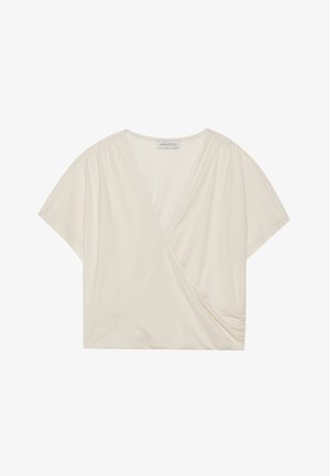 Cream-colored wrap top with short sleeves, made of soft fabric. Features a V-neckline and side ruching detail for a flattering fit.
