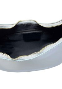 Szara torba na zamek błyskawiczny o gładkiej powierzchni i teksturowanych, jasnoniebieskich krawędziach. Wnętrze posiada czarne wykończenie oraz dyskretną kieszeń na zamek.