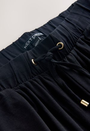 Schwarzer elastischer Bund mit Kordelzug und goldenen Ösen. Weicher Stoff mit geraffter Textur, etikettiert mit "NEXT Petite".