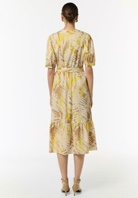 Floral Midi-Kleid in Beige und Gelb, mit Puffärmeln, tailliertem Schnitt und schwingendem Rock. Glattes, leichtes Material mit tropischem Muster.