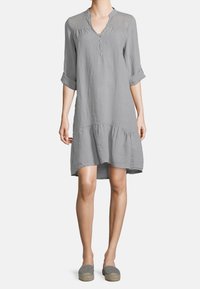 Abito in lino grigio con scollatura a V, apertura con bottoni e dettagli in crochet testurizzato sulle spalle. Presenta un orlo a balze e maniche arrotolate.
