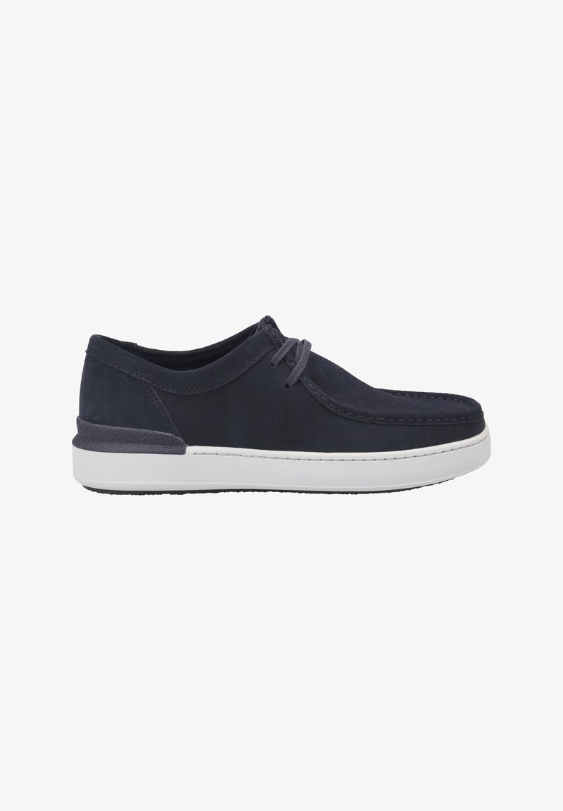 Zapatos de ante azul marino con suela de goma blanca, con un diseño de cordones y costuras visibles a lo largo del borde superior.