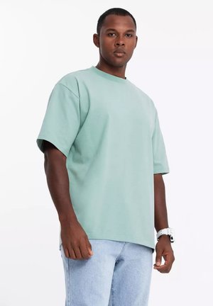 Mintgroen oversized t-shirt van katoen, met een ronde hals, korte mouwen en een relaxed fit. Gestyled met lichtblauwe jeans.