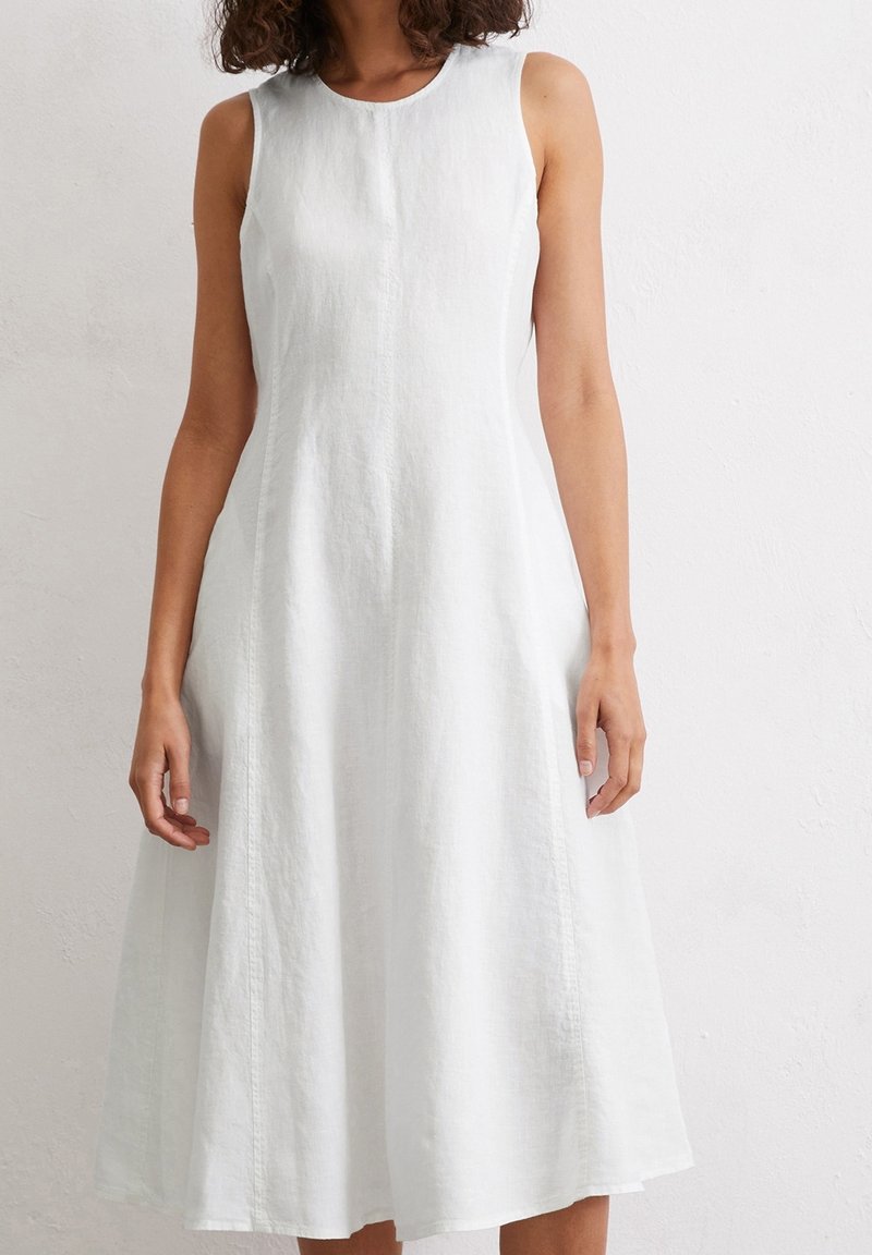 Sleeveless, knee-length white linen dress with a round neckline and A-line silhouette. Features subtle texture and side seams for detail.