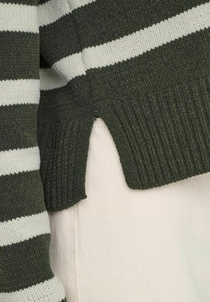 Žalias ir baltas dryžuotas megztinis su tekstūruota medžiaga. Yra raukšlėtos apačios ir šoninių įpjovimų detalės. Minkštas, kasdienis dizainas.