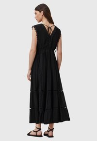 Abito lungo nero con maniche corte, raffinato pizzo decorativo, vita cintata e design a strati. I lacci sul retro aggiungono un tocco di dettaglio.
