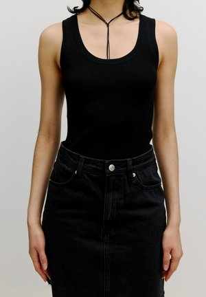 Zwarte geribde tanktop gecombineerd met een hoog-waist zwarte denimrok. Kenmerkt zich door een gladde textuur en zichtbare knopenaccenten.