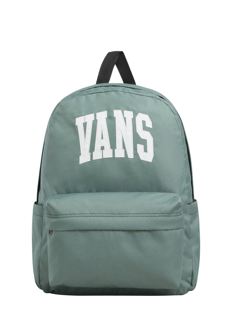 Grön canvasryggsäck med en stor vit "VANS"-logotyp, utrustad med en framficka med dragkedja och svarta justerbara axelremmar. Rundad form och slät textur.